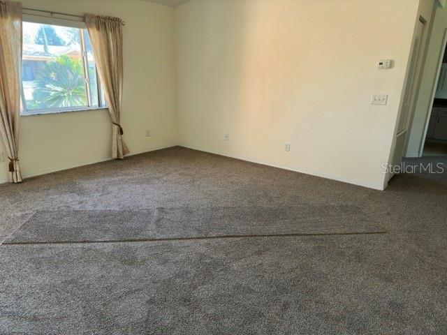 spare room featuring dark carpet