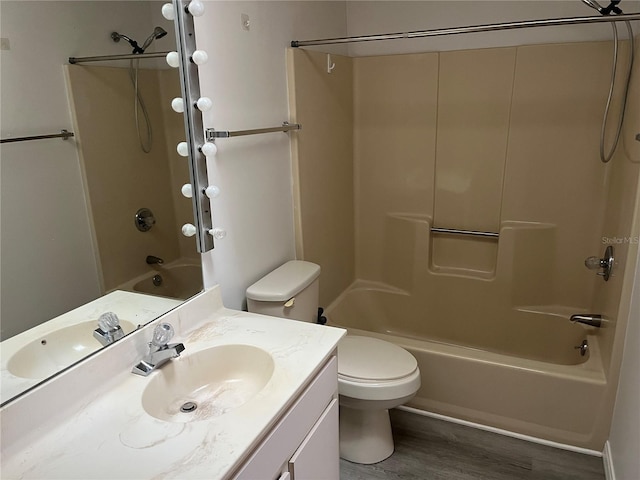 full bathroom with hardwood / wood-style floors, vanity, toilet, and shower / washtub combination