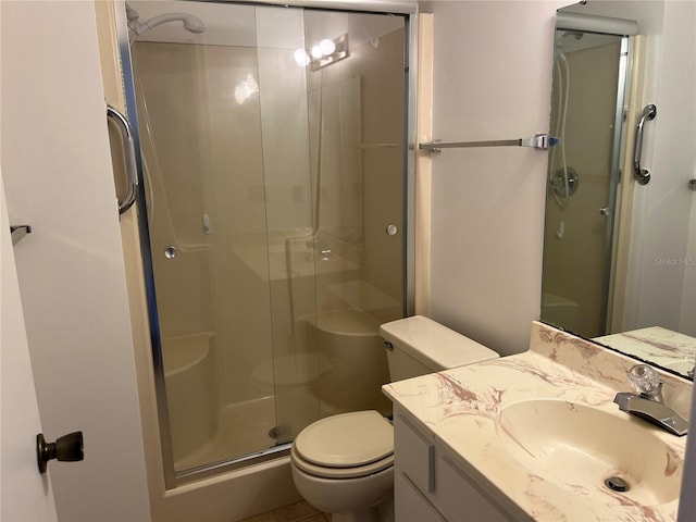 bathroom featuring vanity, toilet, and a shower with door