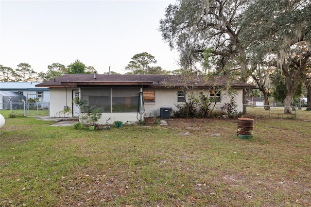 rear view of house featuring a yard and central air condition unit