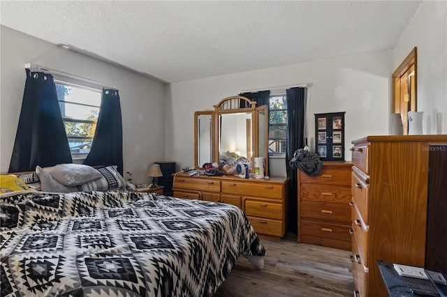 bedroom with a textured ceiling and hardwood / wood-style flooring