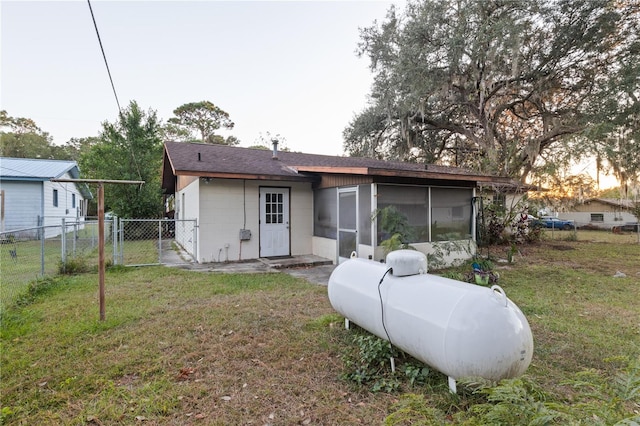 back of property featuring a sunroom and a yard