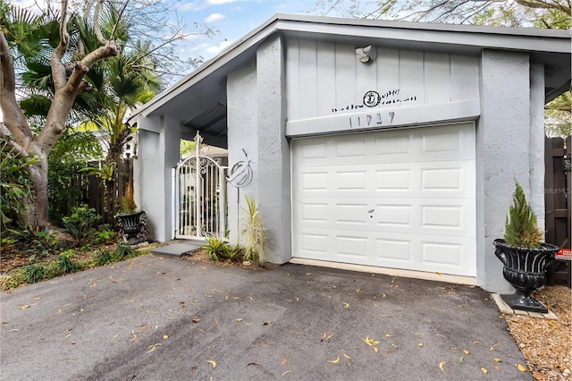 garage with aphalt driveway and a gate