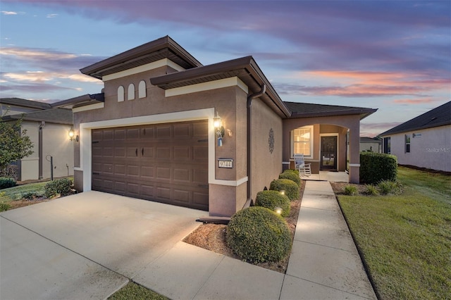 prairie-style home featuring a lawn and a garage