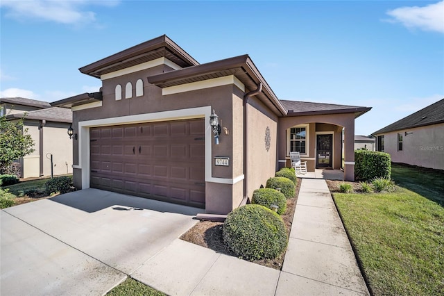 prairie-style house with a porch, a garage, and a front yard