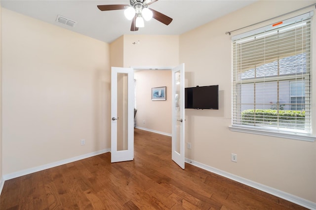 empty room featuring ceiling fan, french doors, and hardwood / wood-style flooring