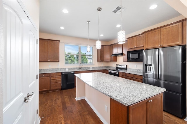 kitchen featuring dark wood-type flooring, a center island, black appliances, and decorative light fixtures