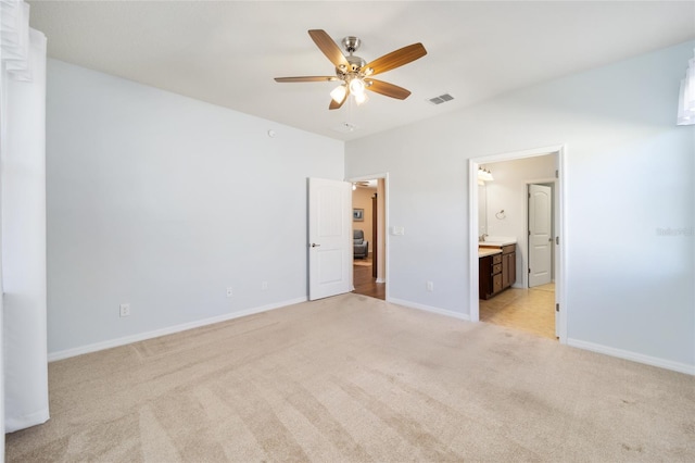 unfurnished bedroom featuring ensuite bathroom, ceiling fan, and light colored carpet