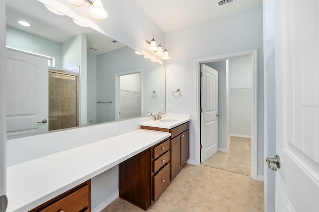 bathroom featuring tile patterned floors, vanity, and a shower with shower door