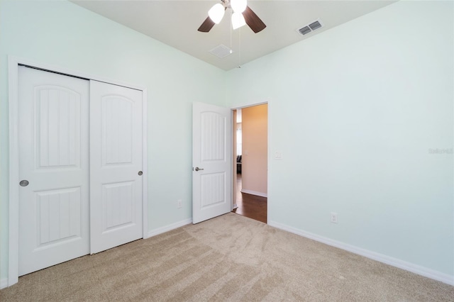 unfurnished bedroom featuring light carpet, a closet, and ceiling fan