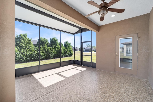 unfurnished sunroom featuring beam ceiling, plenty of natural light, and ceiling fan