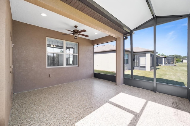 unfurnished sunroom featuring ceiling fan and lofted ceiling with beams