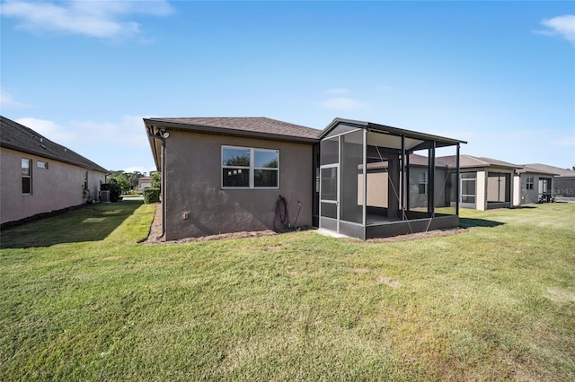 back of house with a sunroom and a lawn