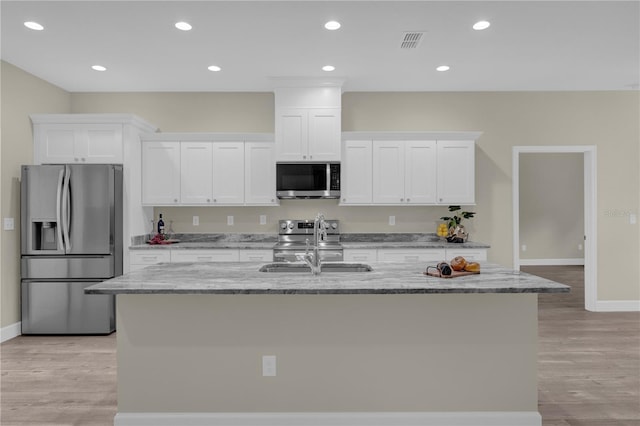 kitchen featuring sink, stainless steel appliances, light hardwood / wood-style flooring, a kitchen island with sink, and white cabinets