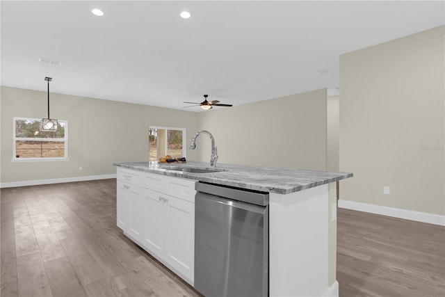 kitchen with a wealth of natural light, a kitchen island with sink, sink, dishwasher, and white cabinetry