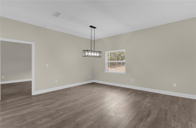 12205 SW 71st Lane Rd, Ocala, FL 34481 - unfurnished room with dark wood-type flooring and a chandelier