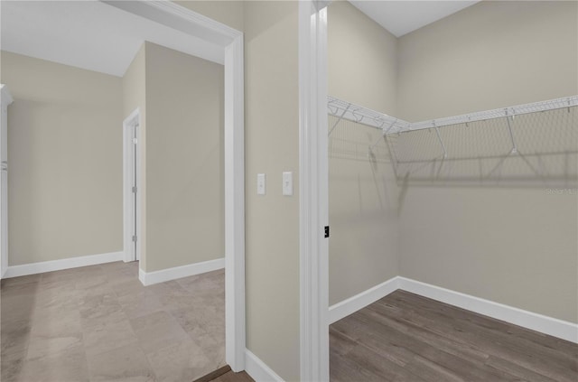 walk in closet with hardwood / wood-style flooring