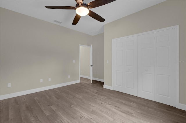 unfurnished bedroom featuring ceiling fan, a closet, and light hardwood / wood-style floors