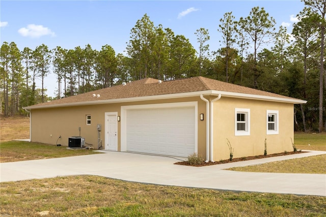 garage with central air condition unit and a yard