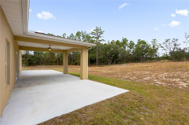 view of yard with ceiling fan and a patio