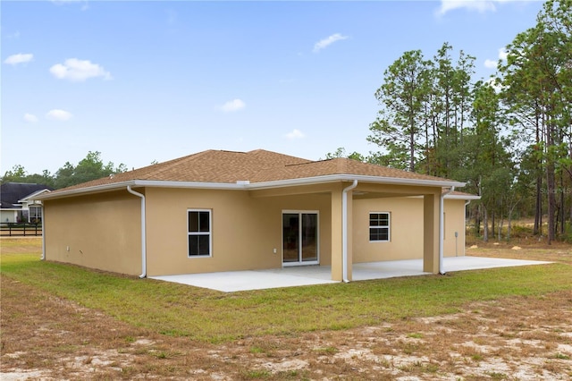 back of property with a lawn and a patio area