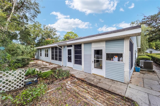 rear view of property with central AC unit and a patio