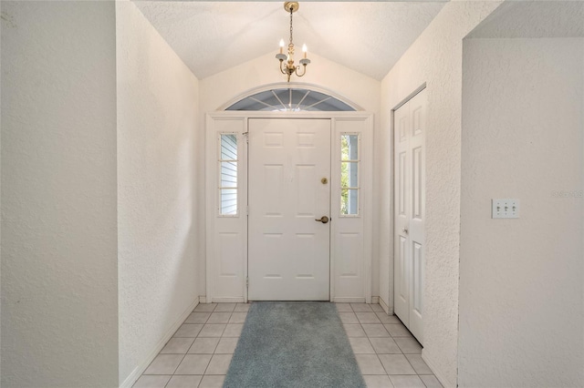 tiled foyer entrance featuring lofted ceiling and a notable chandelier