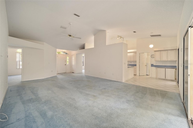 unfurnished living room with ceiling fan, high vaulted ceiling, and light tile patterned floors