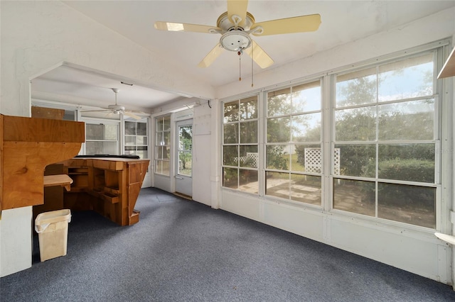 unfurnished sunroom with ceiling fan and vaulted ceiling