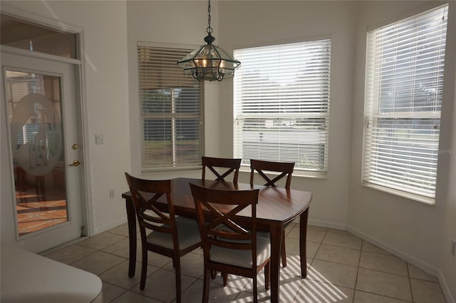 tiled dining space with a chandelier