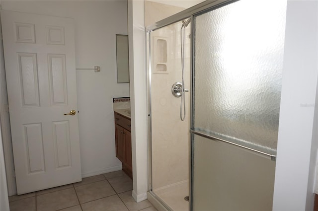 bathroom featuring vanity, a shower with door, and tile patterned flooring