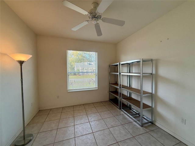 spare room with light tile patterned floors, baseboards, and a ceiling fan