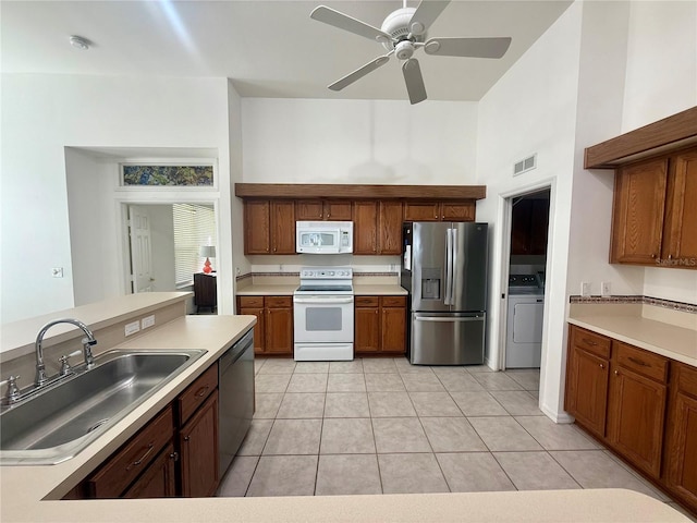 kitchen featuring washer / clothes dryer, light countertops, visible vents, appliances with stainless steel finishes, and a sink