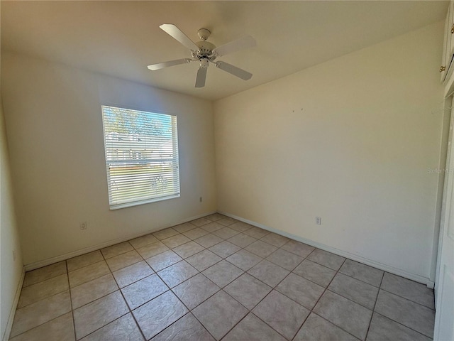 spare room with light tile patterned floors and a ceiling fan