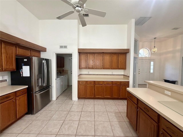 kitchen with light countertops, stainless steel fridge, visible vents, and brown cabinets