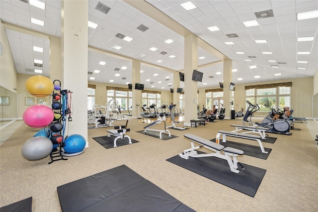 exercise room featuring plenty of natural light, visible vents, and a drop ceiling