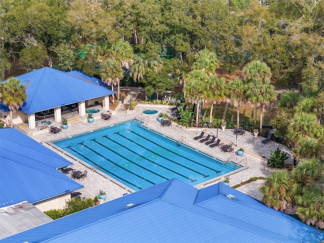 community pool with a patio area and fence