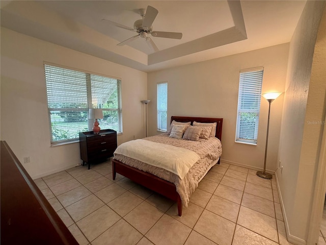 6688 SW 113th Pl, Ocala, FL 34476 - bedroom with light tile patterned flooring, a raised ceiling, a ceiling fan, and baseboards