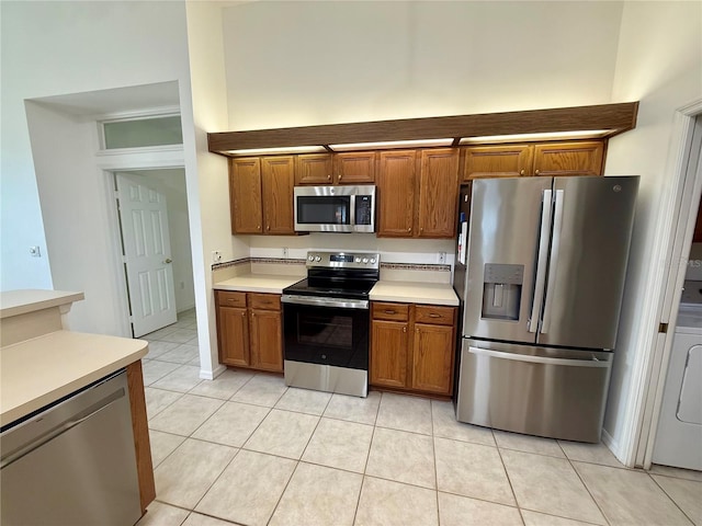 6688 SW 113th Pl, Ocala, FL 34476 - kitchen featuring stainless steel appliances, brown cabinets, light countertops, and light tile patterned floors