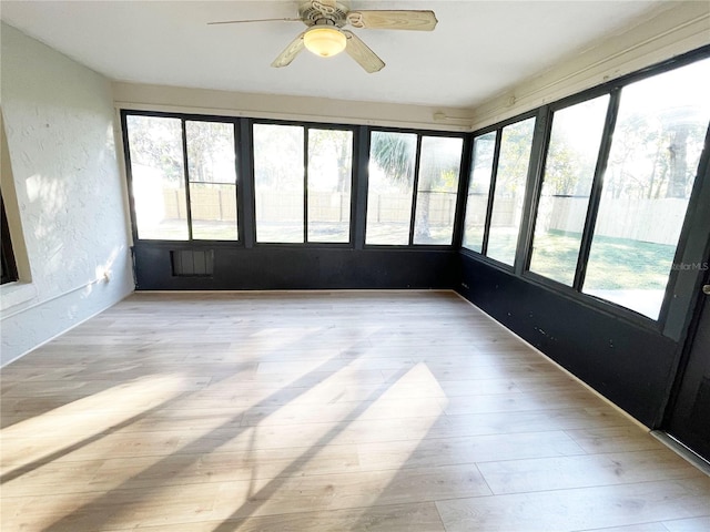 unfurnished sunroom with ceiling fan