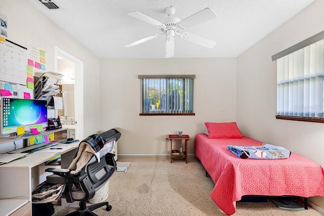 carpeted bedroom featuring multiple windows, ceiling fan, and a textured ceiling