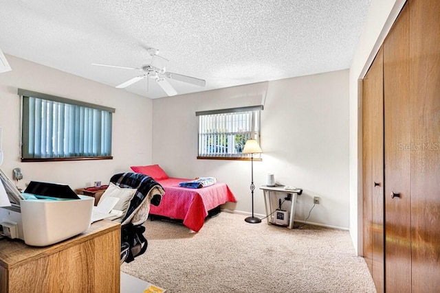 bedroom featuring carpet flooring, ceiling fan, a textured ceiling, and a closet