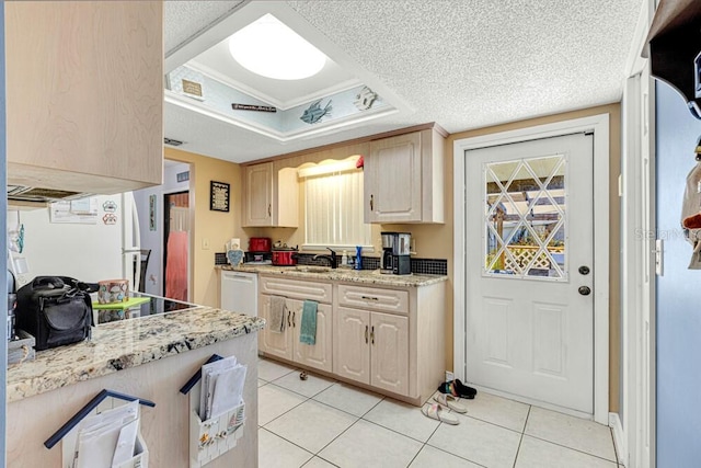 kitchen with light stone countertops, a textured ceiling, a tray ceiling, light brown cabinetry, and light tile patterned floors