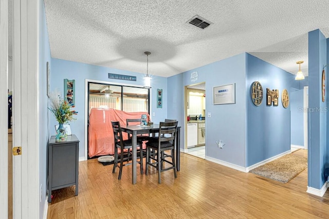 dining space featuring hardwood / wood-style floors and a textured ceiling