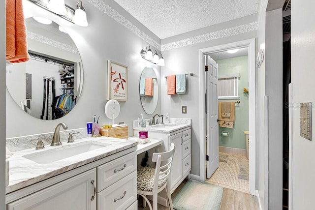 bathroom with vanity, a textured ceiling, and hardwood / wood-style flooring