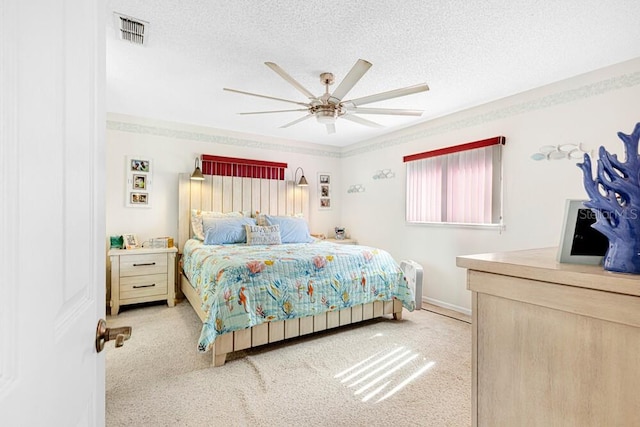 carpeted bedroom with ceiling fan and a textured ceiling