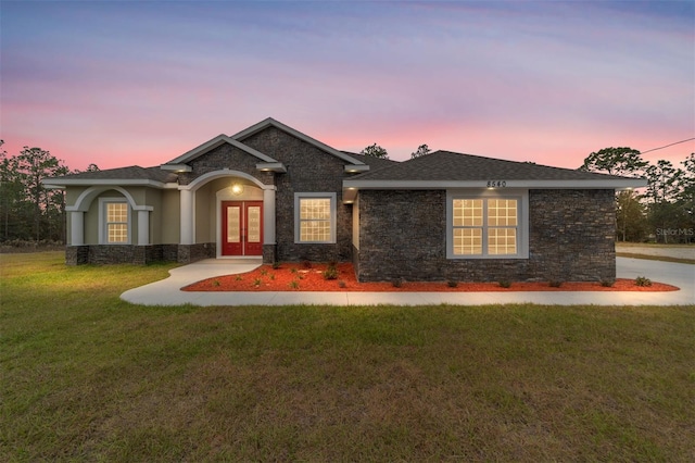 view of front of home with a lawn and french doors