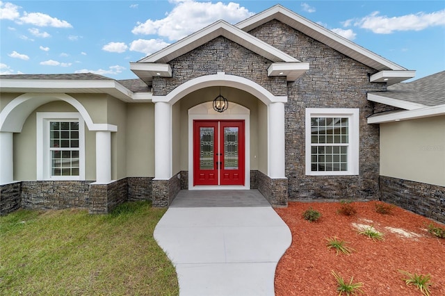 entrance to property with french doors and a lawn