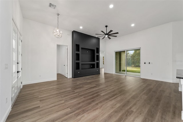 unfurnished living room with ceiling fan with notable chandelier and dark hardwood / wood-style floors