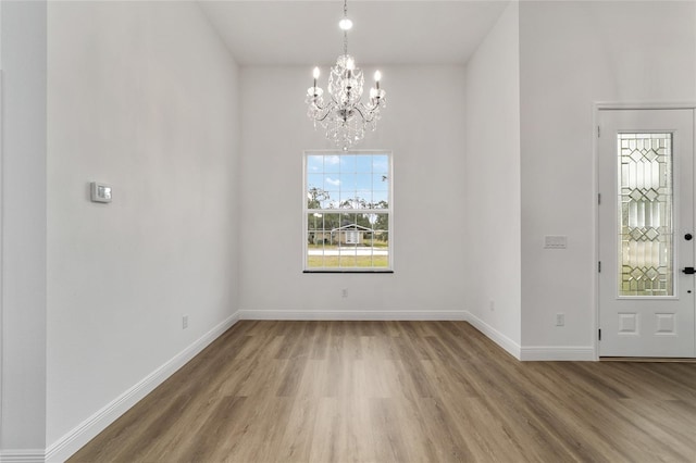 entrance foyer with wood-type flooring and an inviting chandelier